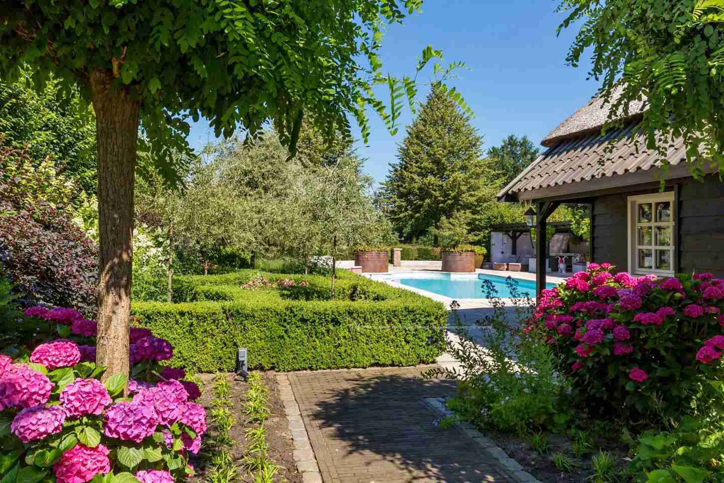 Luxe villatuin met zwembad en poolhouse, ontworpen door Florera